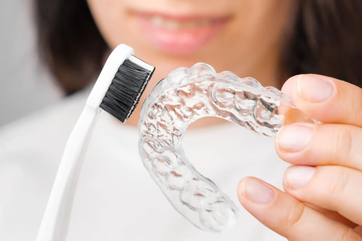 Cleaning retainers with a soft toothbrush and gentle brushing to prevent damage and bacterial build-up.