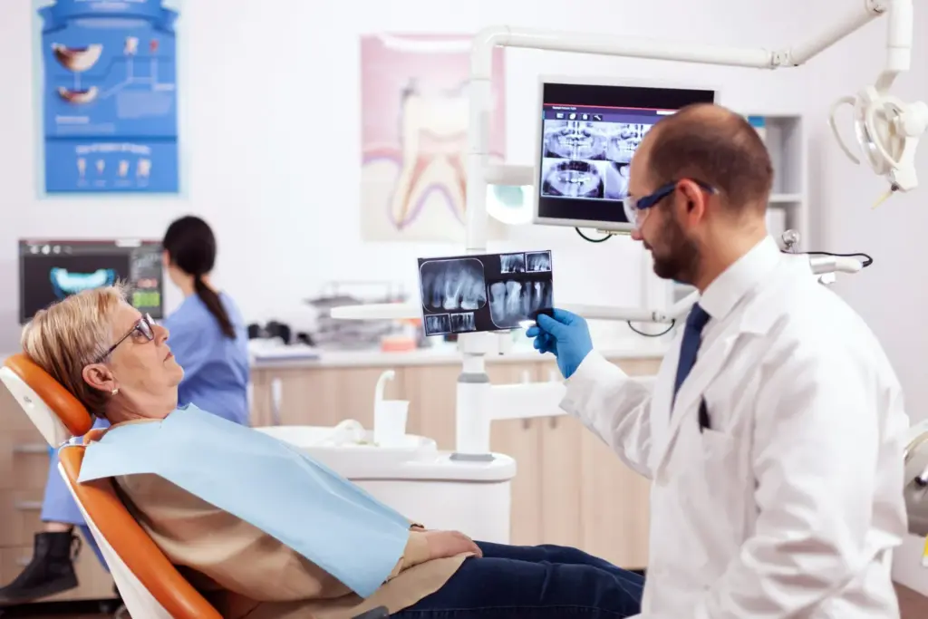 Dentist reviewing jaw X-ray while discussing the dental bone graft procedure and healing timeline.
