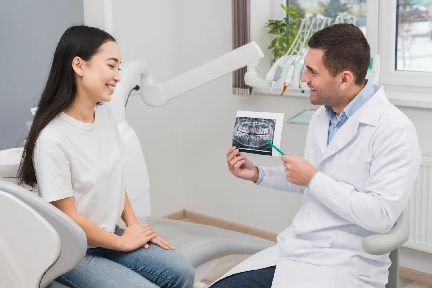 Dentist discussing X-ray results with a patient to explain their oral health and suggested check-up timing.