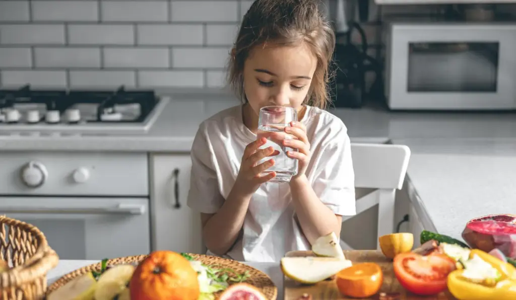 Child drinking water between meals to support healthy teeth.