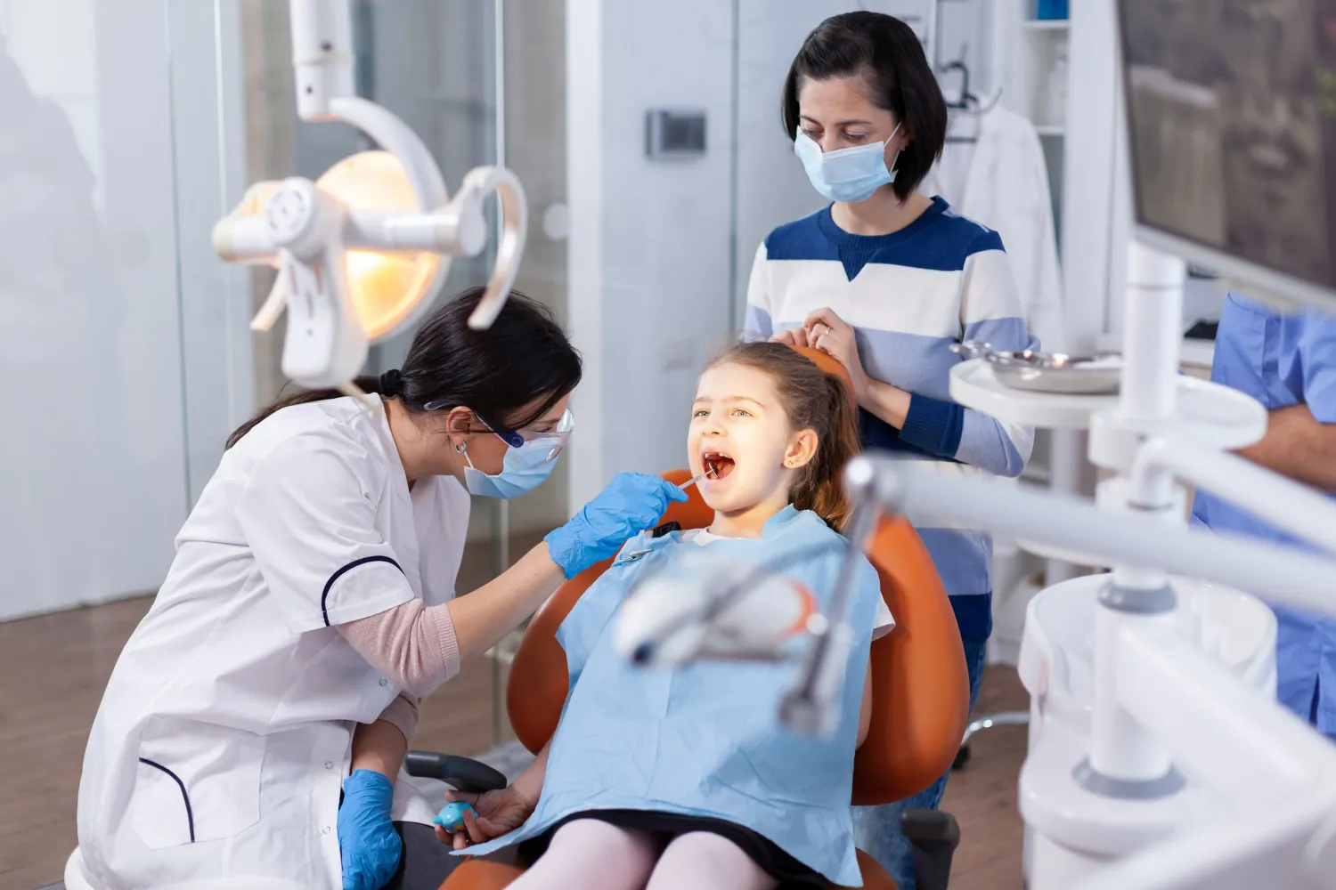 Child receiving an urgent dental check-up with a parent present after a knocked-out tooth.