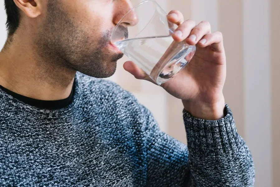 Man gargling warm salt water as short-term home care for a cracked tooth.