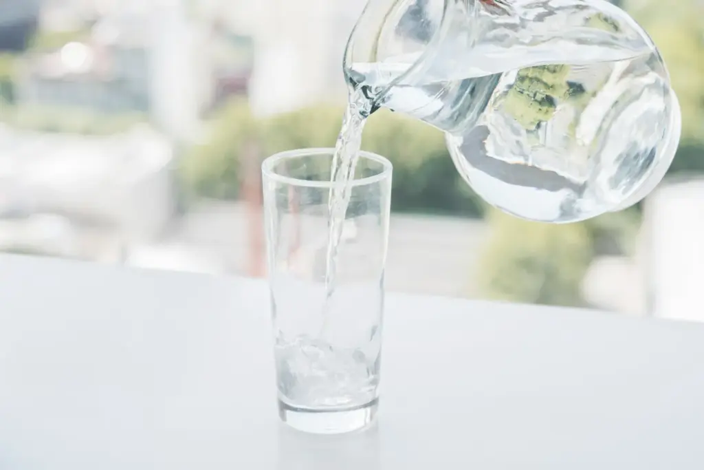 Water being poured into a glass, showing a tooth-friendly everyday drink.