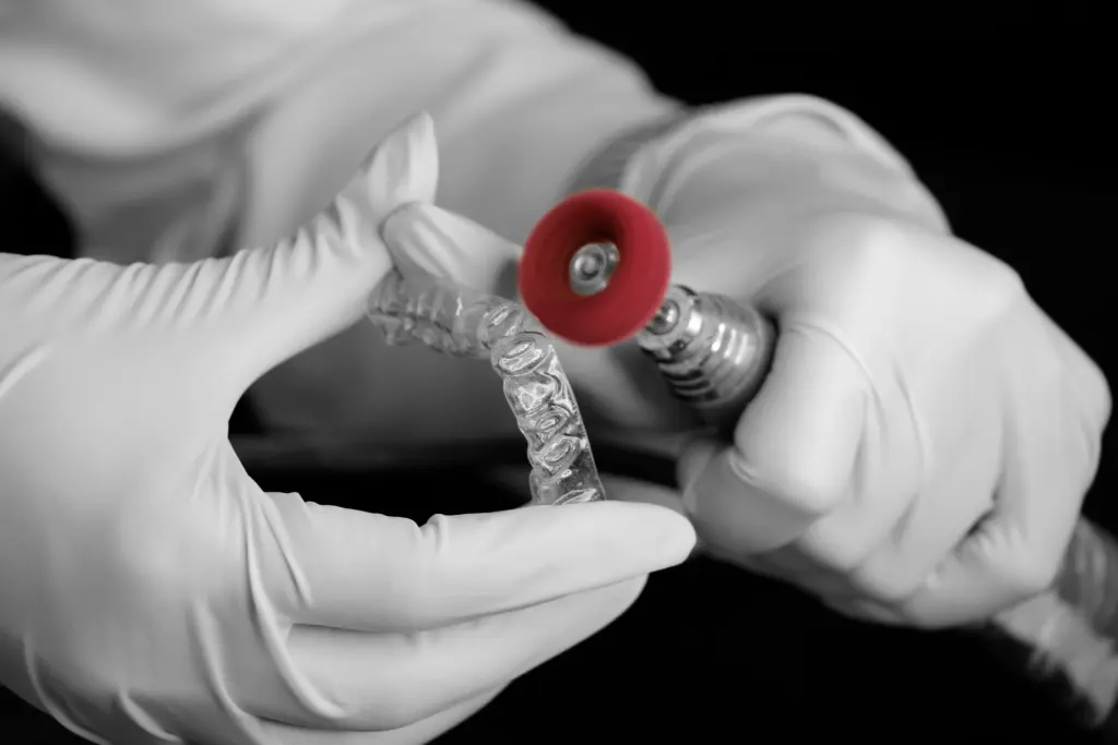 Dental professional checking the shape and condition of a clear aligner.