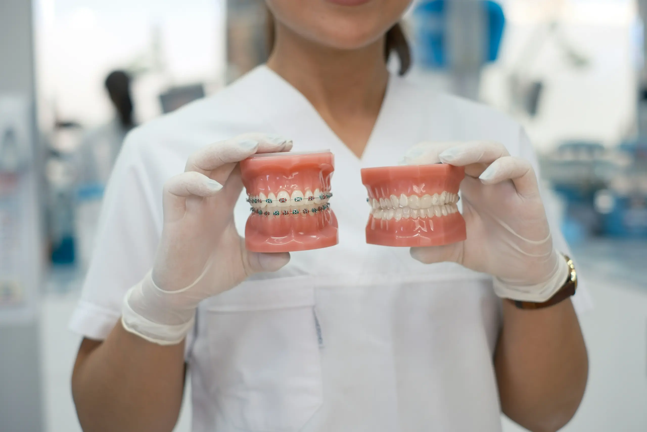 Dental professional comparing clear aligners and fixed braces for orthodontic treatment.